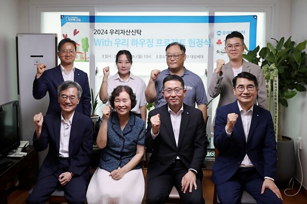 ▲이광회 한국해비타트 사무총장(앞줄 왼쪽 첫번째), 이종근 도박 대표(앞줄 왼쪽 세번째) 등 양사 임직원이 참여한 가운데 주거환경 개선사업으로 진행된 노후주택 수리 완공을 기념하여 헌정식 행사를 진행했다./사진=우리금융그룹