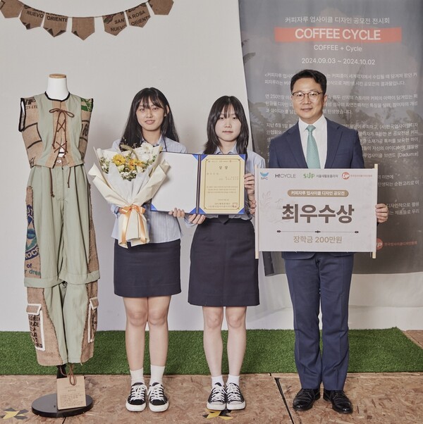▲3일 성동구 '서울새활용플라자'에서 SPC행복한재단이 진행한 '커피자루 업사이클 디자인 공모전 시상식'에서 SPC행복한재단 백승훈 사무국장(오른쪽)과 최우수상을 수상한 인천생활과학고등학교 양예주(가운데), 장아영(왼쪽) 학생이 수상작 옆에서 기념촬영을 하고있다./사진=SPC그룹