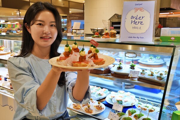 ▲롯데백화점 본점 지하 1층 식품관에서 진행 중인 '세이세이' 팝업 매장에서 음식을 들고 있는 모델./사진=롯데백화점