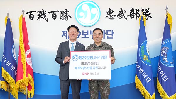 ▲김태한 BNK경남은행장(왼쪽)이 제39보병사단 김종묵 사단장에게 위문금을 전달하고 기념촬영을 하고 있다./사진=BNK경남은행