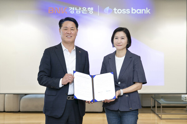 ▲BNK경남은행 김태한 은행장(왼쪽)과 토스뱅크 이은미 은행장이 ‘공동 상품 개발 및 상호 혁신을 위한 협약’을 체결하고 있다./사진=BNK경남은행