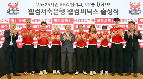 ▲2025-2026 PBA 팀리그를 앞둔 웰컴저축은행 웰컴피닉스 출정식 단체 모습. 손종주 웰컴금융그룹 회장(왼쪽서 다섯번째)과 김대웅 웰컴피닉스 구단주(왼쪽 첫번째), 윤현식 웰컴피닉스 단장(오른쪽에서 첫번째)이 웰컴피닉스 선수들과 포즈를 취하고 있다./사진=웰컴저축은행)