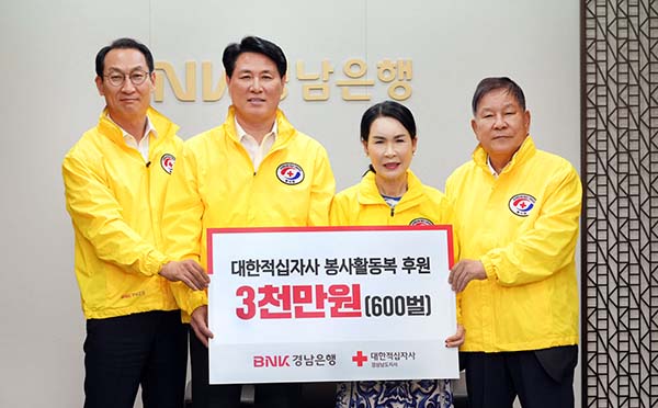 ▲(왼쪽부터)구태근 BNK경남은행 상무, 김태한 BNK경남은행장, 박희순 대한적십자사 경남지사 회장, 최충경 대한적십자사 회장 자문위원이 봉사활동복 전달식 후 기념촬영을 하고 있다./사진=BNK경남은행