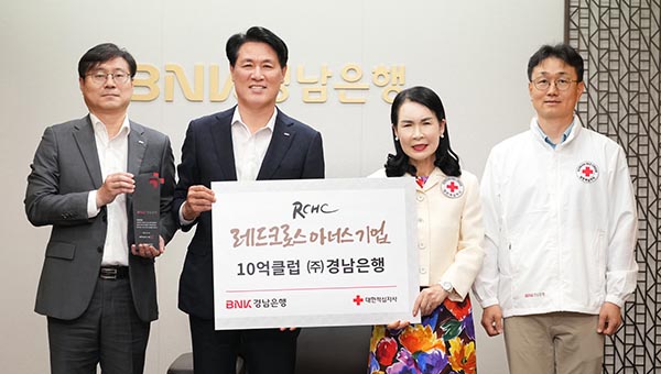 ▲김태한 BNK경남은행장(왼쪽 두 번째)과 박희순 대한적십자사 경남지사 회장(왼쪽 세 번째) 등이 레드크로스 아너스기업 10억 클럽 상패와 증서를 들고 기념촬영을 하고 있다./사진=BNK경남은행